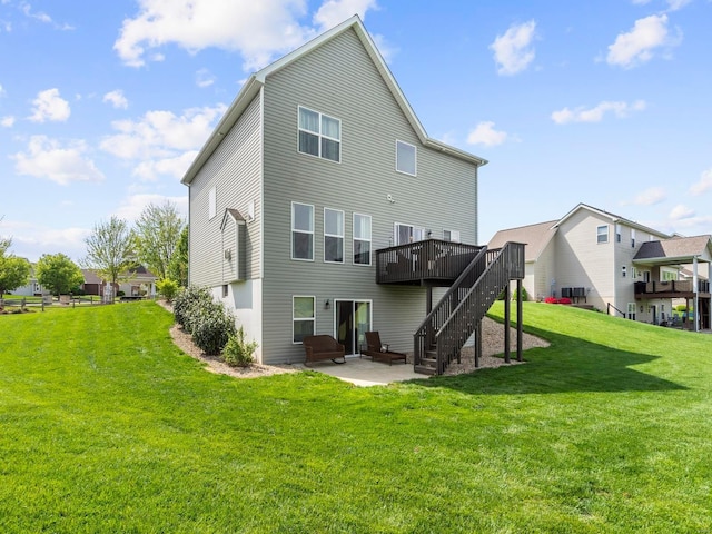 rear view of property with a wooden deck, central AC, stairs, a patio area, and a yard