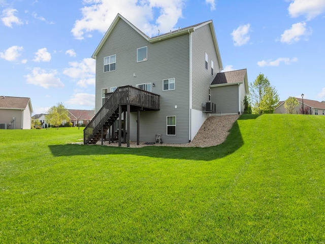 rear view of property featuring stairs, central AC, a yard, and a deck