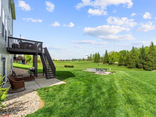 view of yard with a wooden deck, a patio, stairs, and a fire pit