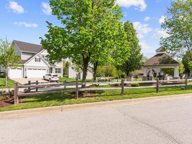 view of front of house featuring fence, a gazebo, driveway, and an attached garage