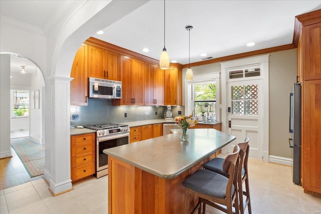 kitchen with a center island, recessed lighting, arched walkways, and stainless steel appliances