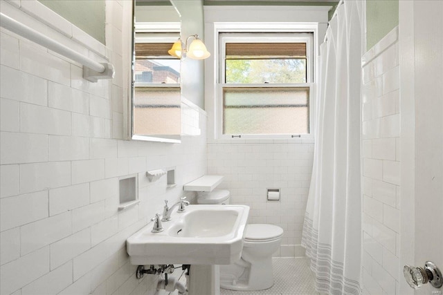 bathroom with toilet, a shower with curtain, tile walls, and tile patterned floors
