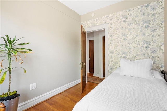 bedroom featuring baseboards and wood finished floors