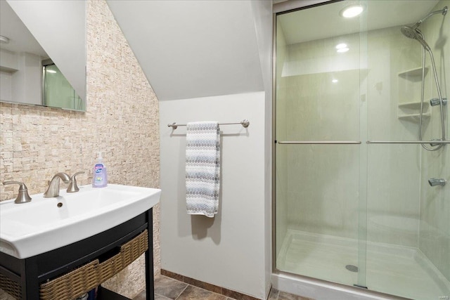 full bath with a stall shower, lofted ceiling, vanity, and decorative backsplash