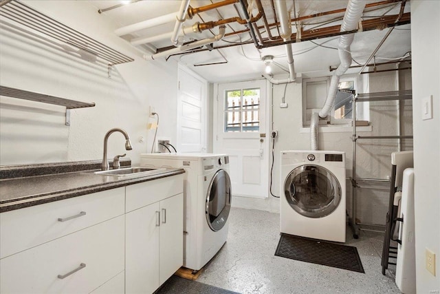 laundry area featuring washer and clothes dryer, cabinet space, and a sink