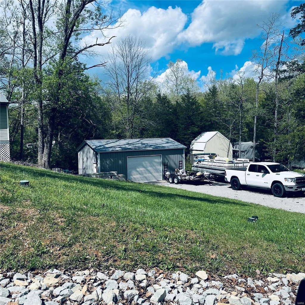 view of yard with a detached garage and an outdoor structure