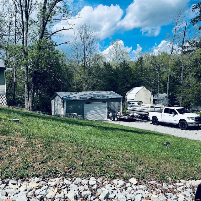 view of yard with a detached garage and an outdoor structure