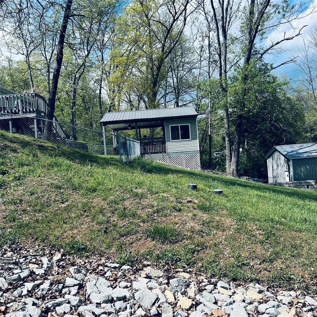 view of outdoor structure with fence and an outbuilding
