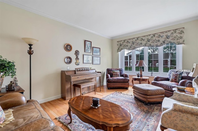living area with crown molding, baseboards, and light wood finished floors