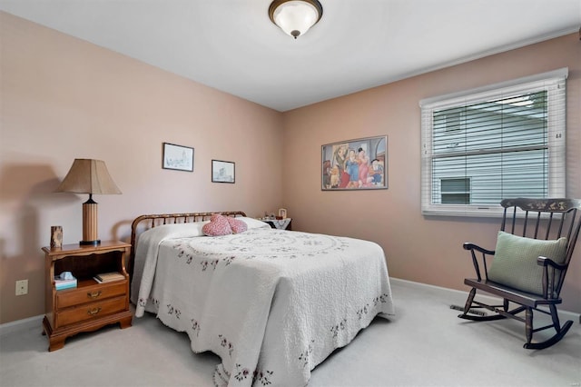 bedroom with baseboards and light colored carpet