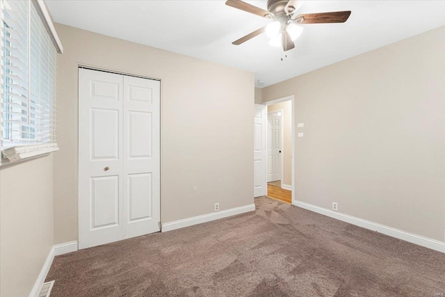 unfurnished bedroom with a closet, baseboards, a ceiling fan, and carpet flooring