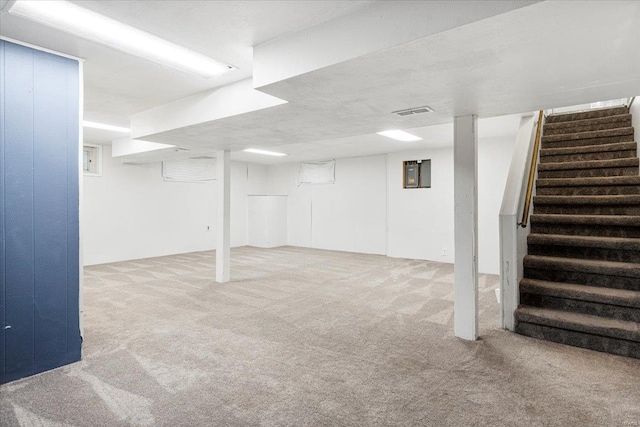 finished below grade area with visible vents, carpet flooring, and stairs