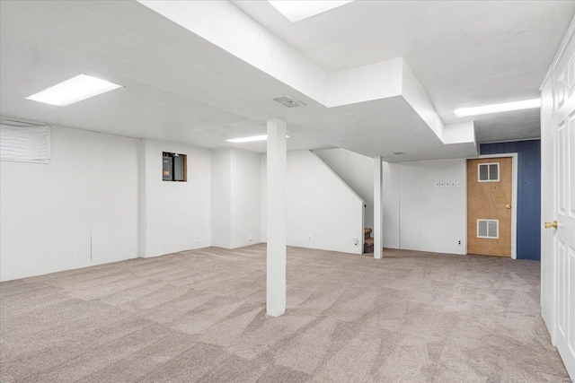 finished basement featuring carpet floors, stairs, and visible vents