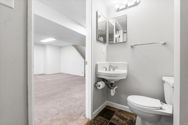 bathroom with baseboards, a sink, and toilet