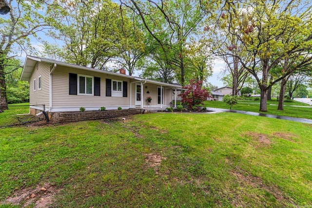 ranch-style house featuring covered porch, fence, a chimney, and a front lawn