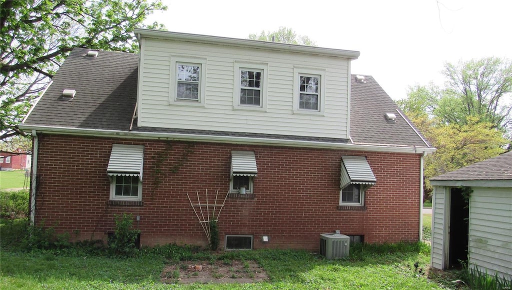 rear view of house featuring brick siding and central air condition unit