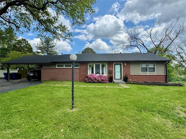 ranch-style home with brick siding, driveway, a front yard, and a carport