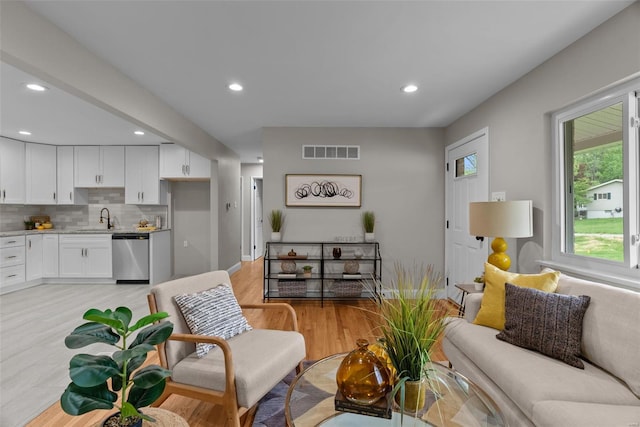 living room featuring recessed lighting, visible vents, and light wood-type flooring