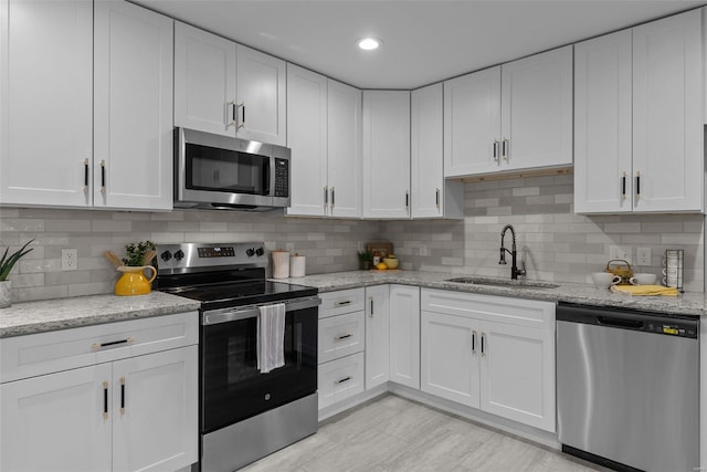 kitchen with a sink, appliances with stainless steel finishes, and white cabinets
