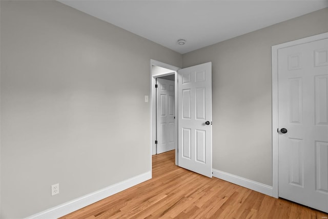 unfurnished bedroom with baseboards and light wood finished floors