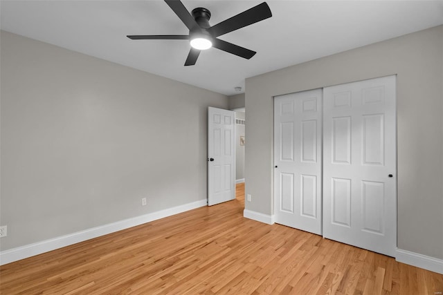 unfurnished bedroom with light wood-style floors, baseboards, a ceiling fan, and a closet