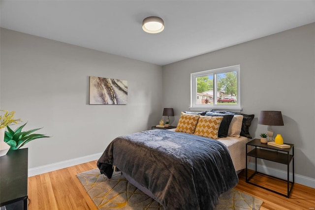 bedroom with baseboards and light wood finished floors