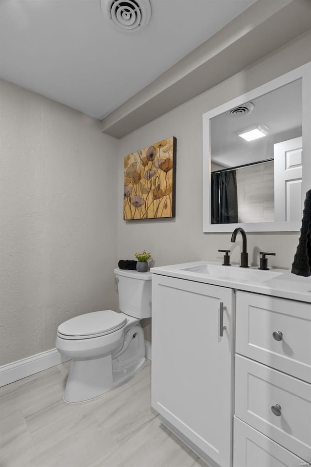 full bathroom featuring toilet, baseboards, visible vents, and vanity