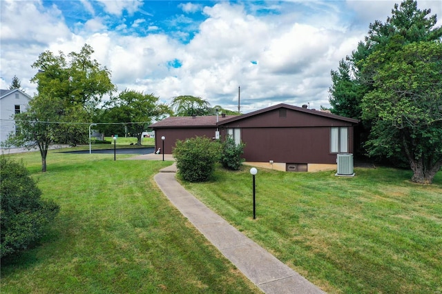 view of home's exterior featuring central AC and a yard