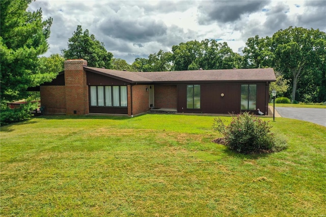view of front facade with a chimney and a front lawn
