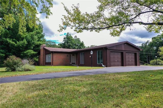 ranch-style home featuring driveway, a chimney, a front yard, a garage, and brick siding