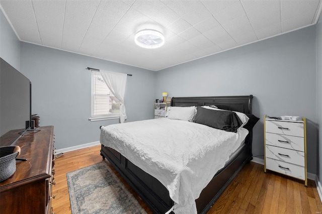 bedroom featuring baseboards and wood finished floors