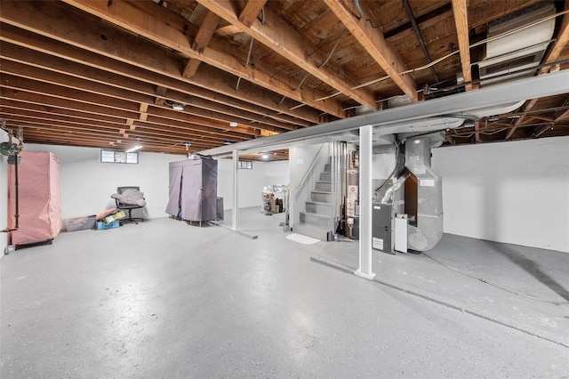 basement with heating unit, stairway, and gas water heater