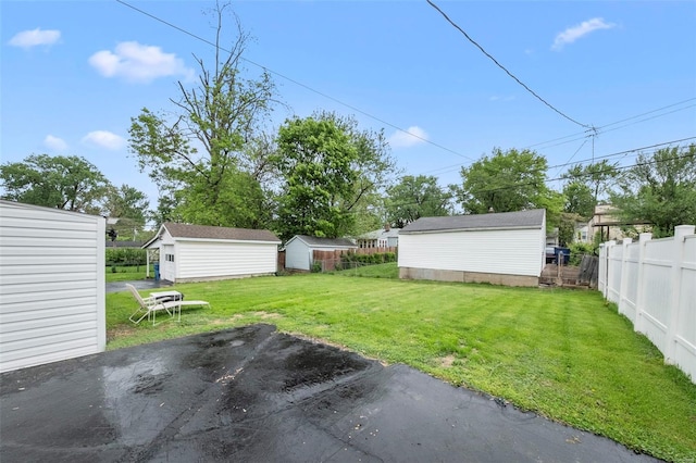 view of yard with a storage unit, an outdoor structure, and fence