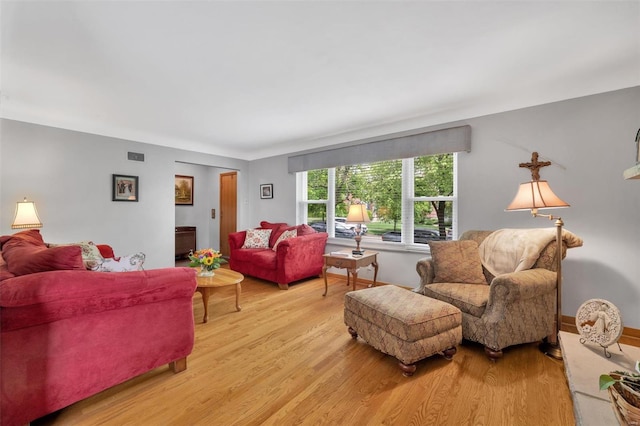 living area featuring light wood finished floors and visible vents