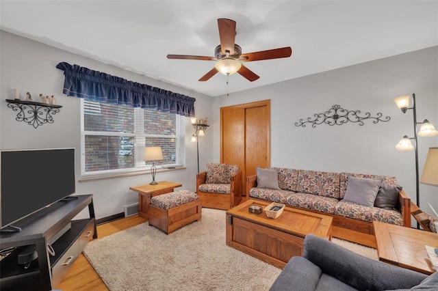 living room featuring ceiling fan, visible vents, and wood finished floors