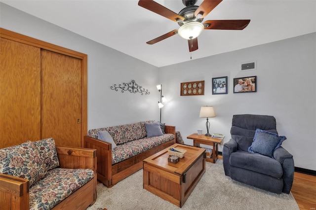 living room featuring visible vents, baseboards, and ceiling fan