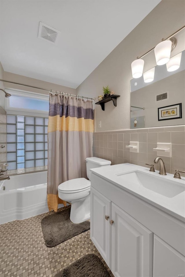 bathroom featuring toilet, tile walls, visible vents, and vanity