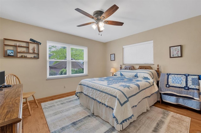 bedroom with baseboards, ceiling fan, and wood finished floors