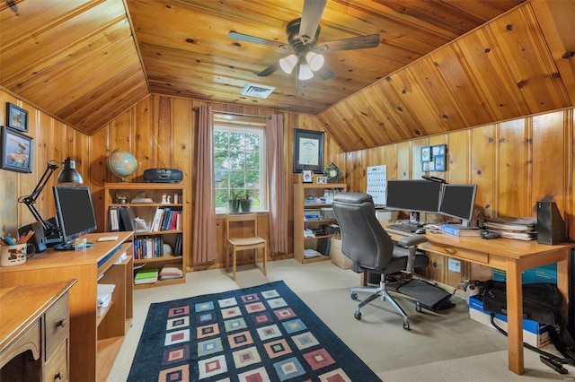 carpeted office with wooden walls, ceiling fan, and vaulted ceiling