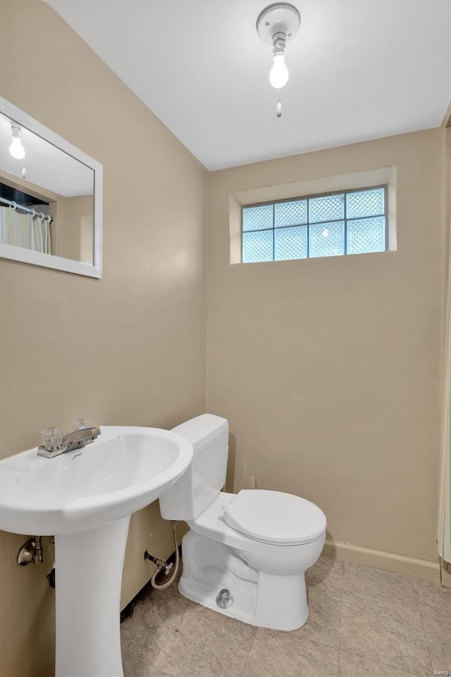 bathroom featuring baseboards and toilet