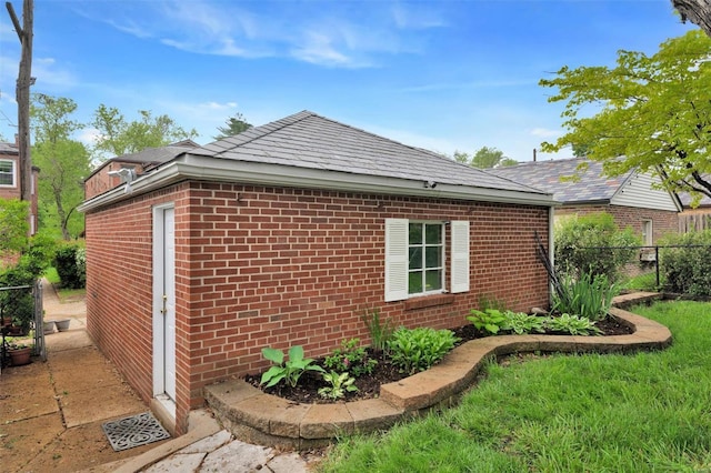 view of side of property with fence and brick siding