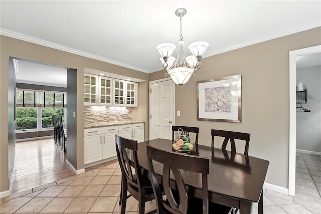 dining area with a chandelier, light tile patterned flooring, crown molding, and baseboards