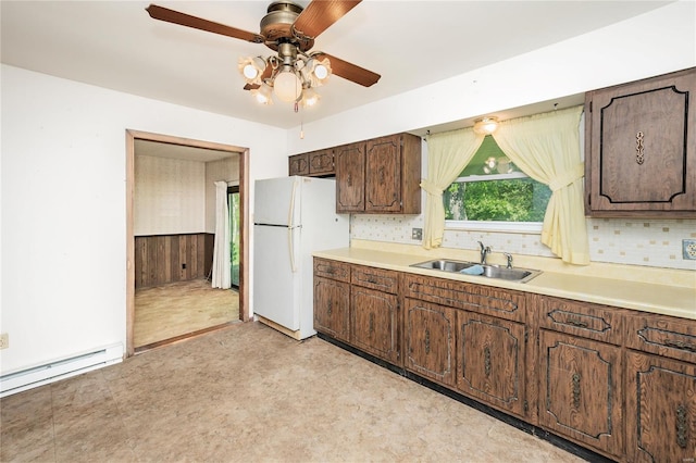 kitchen with a sink, ceiling fan, light countertops, freestanding refrigerator, and light floors