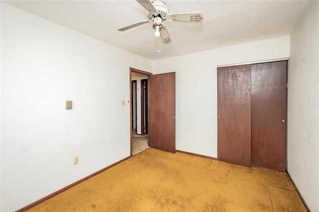 unfurnished bedroom with a closet, ceiling fan, light carpet, and baseboards