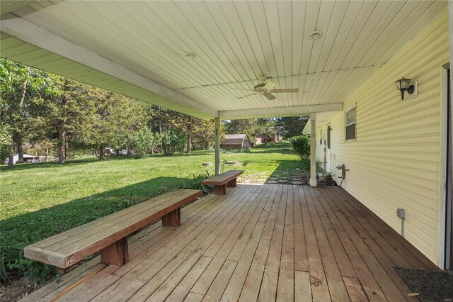 wooden deck with a lawn and a ceiling fan