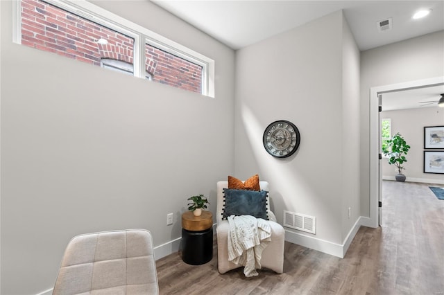 sitting room featuring wood finished floors, visible vents, and baseboards