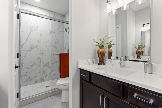 bathroom featuring tile patterned floors, vanity, toilet, and a marble finish shower