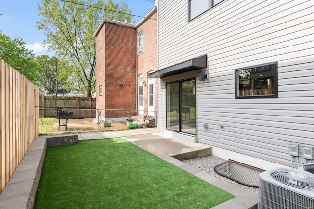 view of yard with central air condition unit and fence