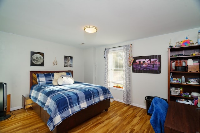 bedroom featuring baseboards and wood finished floors