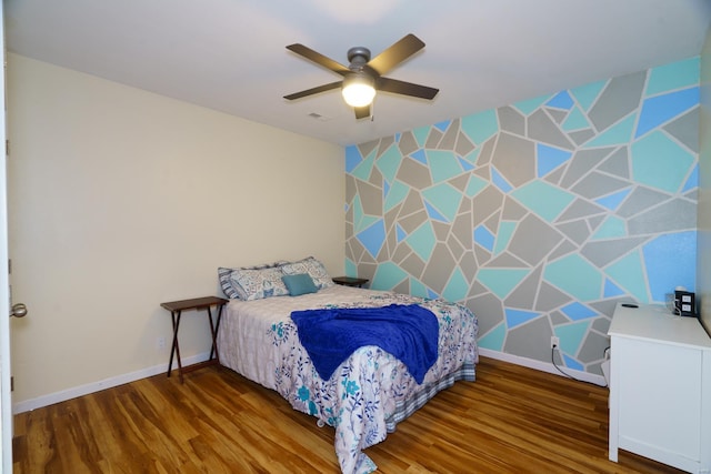 bedroom with wood finished floors, a ceiling fan, visible vents, and baseboards